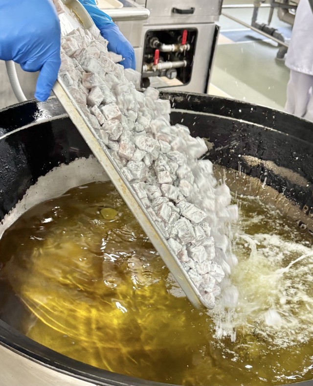 でんぷんをまぶしたさけを揚げる