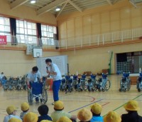 講堂で車いすの使い方の説明を聞く様子