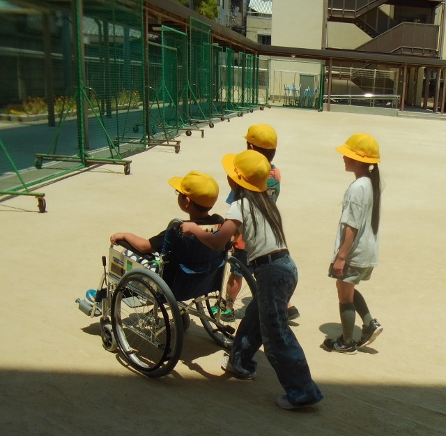 グループで車いすの介助体験をする様子