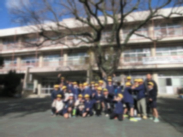 附属平野小学校の前で記念写真を撮る本校4年生児童